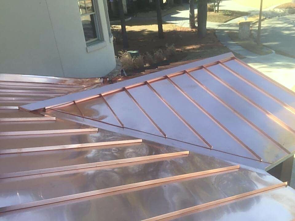 Copper standing seam panels laid out on a roof deck