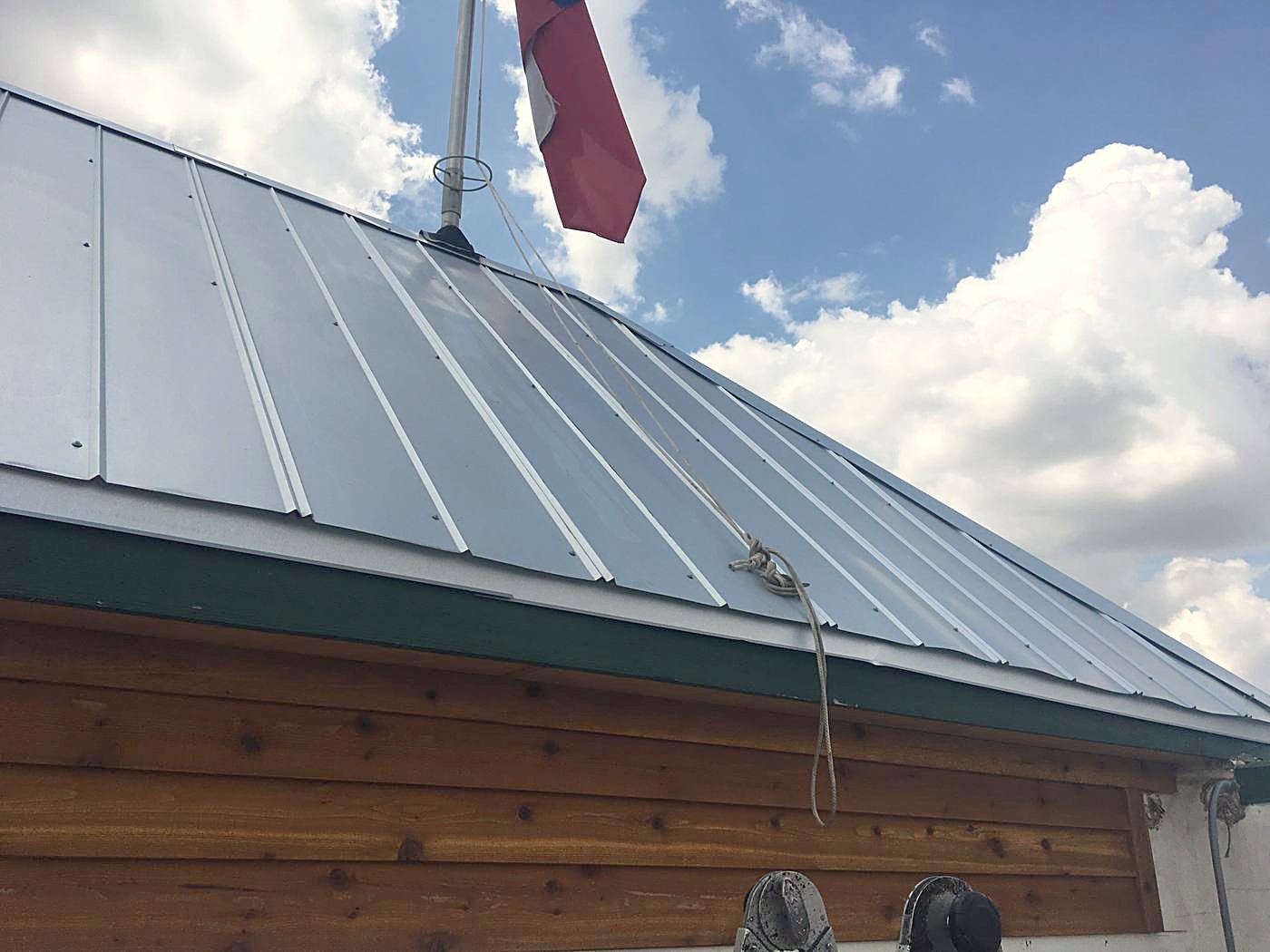 A finished standing seam metal roof under a Texas sky